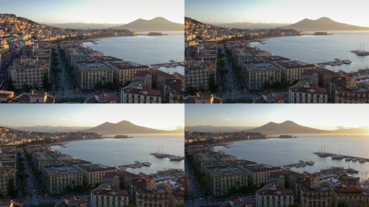 意大利那不勒斯早晨的壮丽全景。汽车驶向城市的街道，船只停靠在海湾。日出时阳光明媚。背景中可以看到维苏