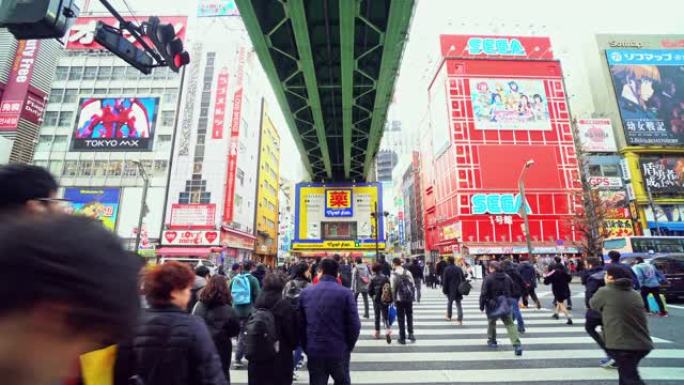 4k镜头行人人群的场景未定义的人走立交桥在日本秋叶原东京市的街道交叉路口。日本文化与电城购物区概念