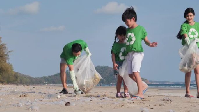 集体幸福的志愿者家庭，在海滩上清理垃圾袋。志愿，慈善，人和生态理念。志愿精神