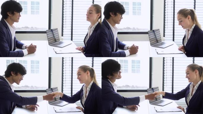人力资源男经理在现代办公室接受工作面试后与女性候选人握手