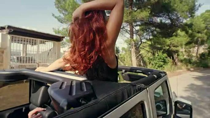 红发女孩在带天窗的SUV里玩得开心