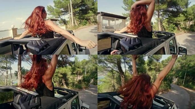红发女孩在带天窗的SUV里玩得开心