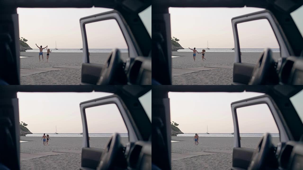 年轻夫妇从汽车跑到海滩