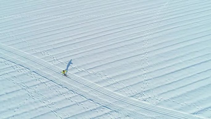 空中: 穿着五颜六色夹克的女人在斯洛文尼亚的一个大雪平原上滑雪。