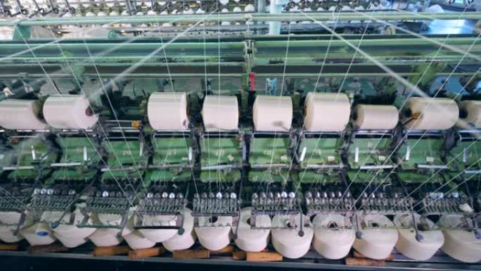 旋转设备线轴在纺织厂用白色纤维切割。