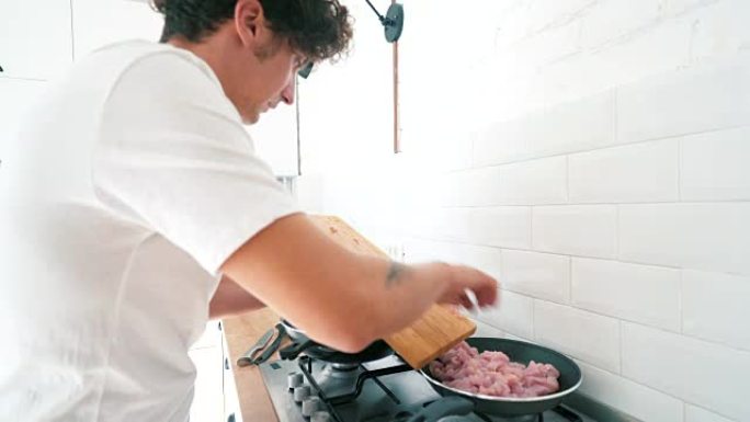 雄性在煎锅里准备鸡肉。