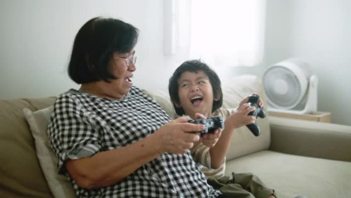 坐在沙发上玩电子游戏的亚洲家庭