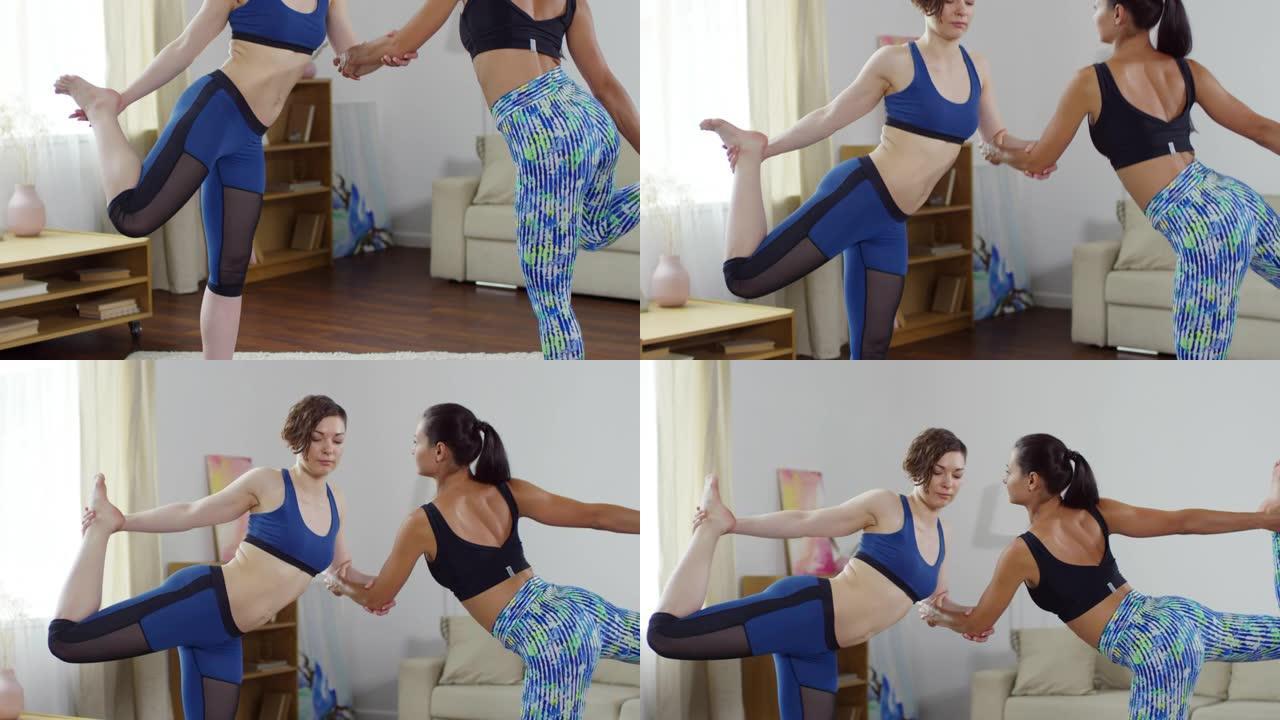 两名女性在伴侣瑜伽锻炼中做双人舞者姿势