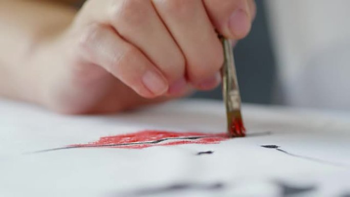 艺术家在织物上的图像上轻拍红色油漆