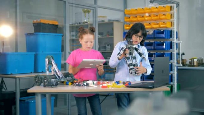 年幼的孩子在实验室里一起工作。学童使用实验室设备来构造玩具机器人。