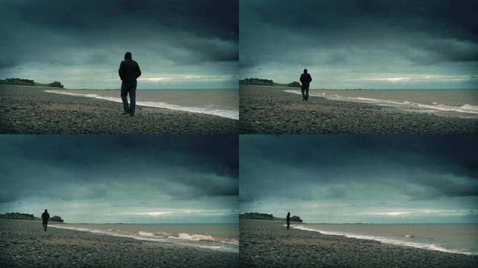 暴风雨中，一名男子走在岩石海滩上