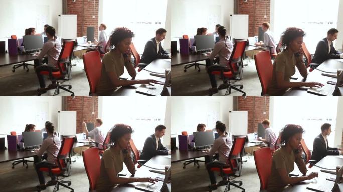 跨国公司员工坐在现代化的共享办公室内