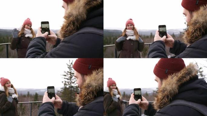 男子在山上徒步旅行时给女友拍照