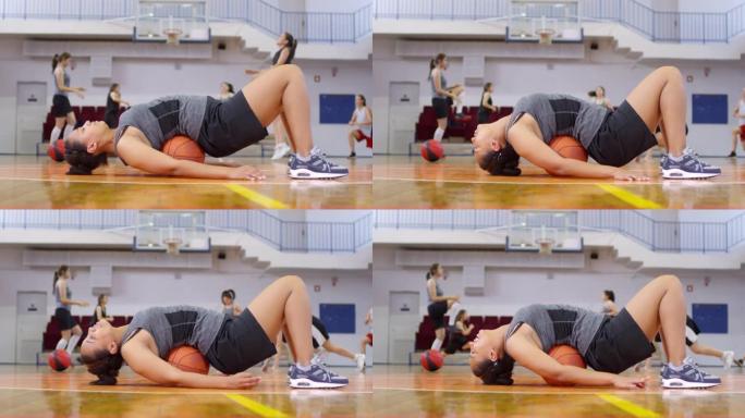 非洲女运动员躺在篮球上做自我按摩