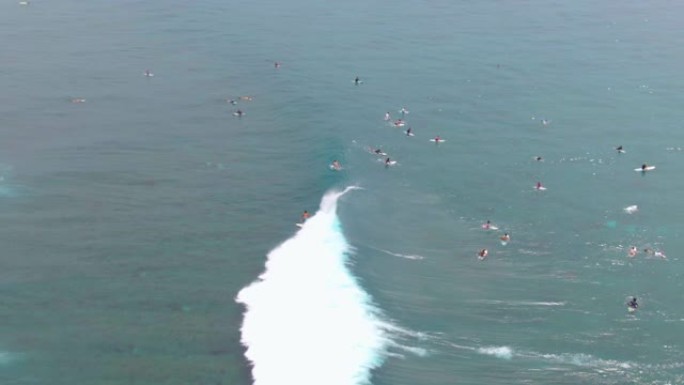 无人机: 巨大的海浪冲过冲浪者，划向队伍。