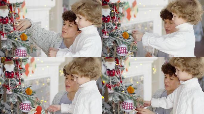 可爱的小男孩和妈妈在家里装饰圣诞树