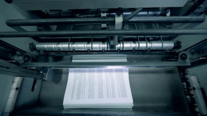 印刷纸堆叠在排版线上，自动化机器。