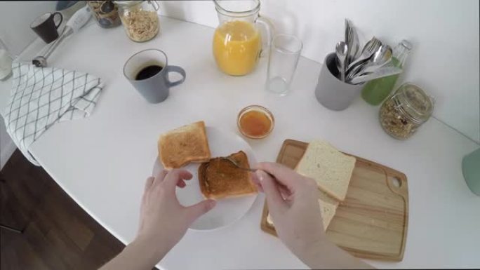 女人做果酱烤面包和早餐果汁的POV