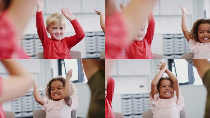 婴儿学童在空中挥舞着手臂，在上课时鼓掌，特写镜头