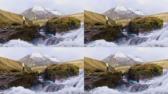 女士站在冰岛Skogafoss瀑布的岩石上