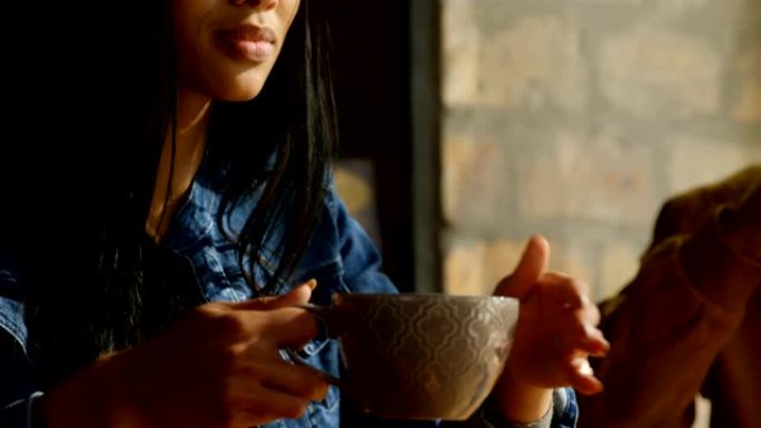 咖啡馆4k年轻漂亮混血女人喝咖啡用手机特写