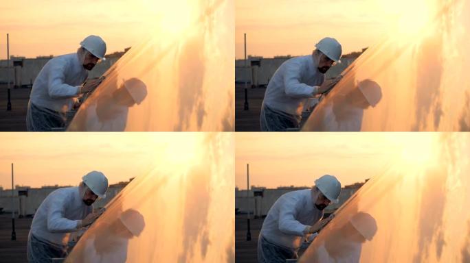 一名男性专家正在擦拭太阳能建筑的阳光表面。环保能源概念。