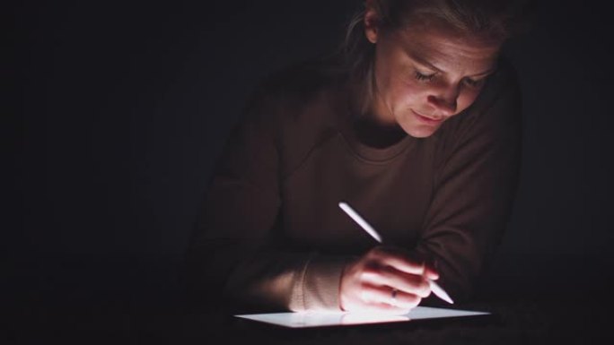 女人晚上用手写笔在数字平板电脑上画画