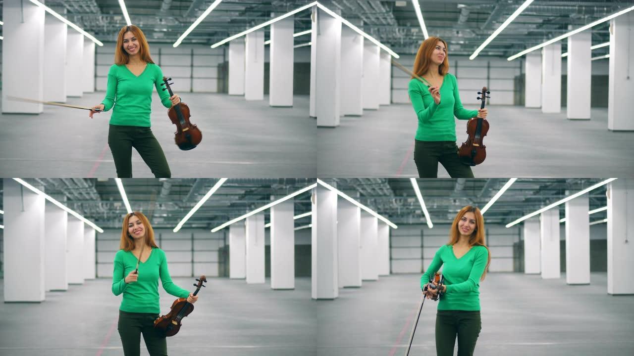 微笑的女人正在玩弓和小提琴