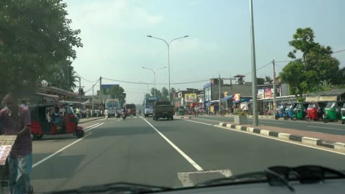 斯里兰卡繁忙，阳光明媚的街道上的MS汽车，公共汽车，人力车和自行车