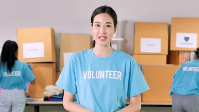 漂亮的志愿者亚洲年轻女性演讲视频会议，在冠状病毒大流行期间捐赠食物银行，用于家庭和社会距离的工作。肖