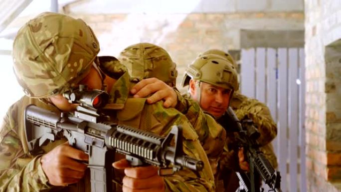 在军事训练4k期间用步枪站立和瞄准的高加索军事士兵的前视图