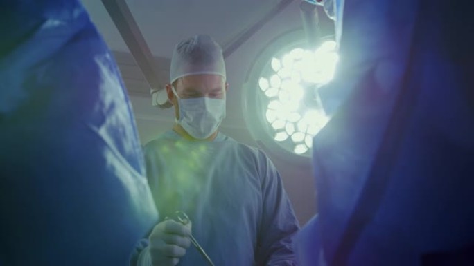 在医院手术室进行手术的高加索男性外科医生的低角度视图