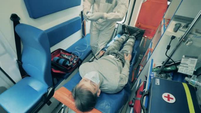 医务人员在救护车中将管子连接到患者的头部。冠状病毒流行，新型冠状病毒肺炎大流行，病毒疾病概念。