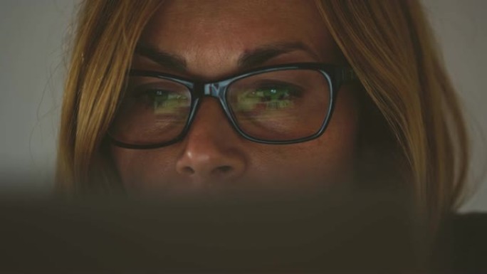 使用笔记本电脑戴眼镜的CU肖像女人