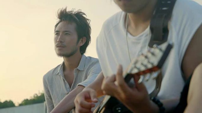 三个年轻的亚洲成年男子唱歌弹吉他