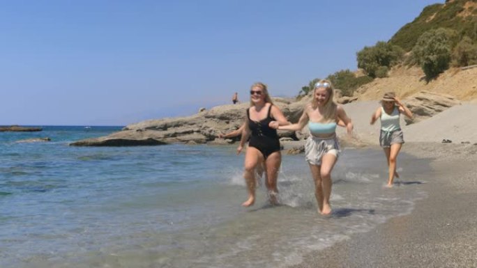 溅过海滩一群女人在海水里奔跑海边海滩