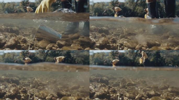 人类的手从河里捡起金属罐