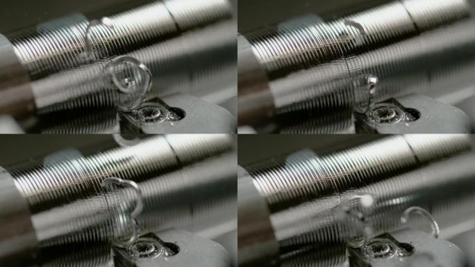 宏观: 螺旋形切屑从铝棒上飞下来，被加工成螺栓