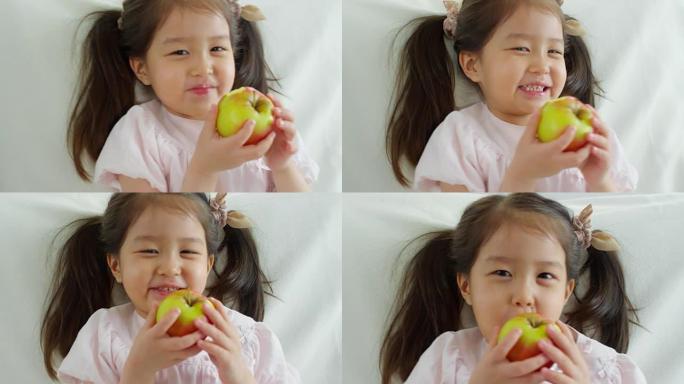 可爱的亚洲女孩吃苹果
