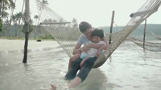 幸福的家庭在海滩的吊床上摇摆休息。