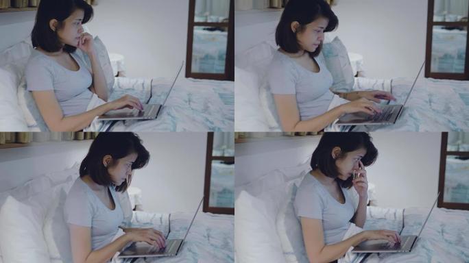 傍晚在家中躺在床上的亚洲妇女使用笔记本电脑