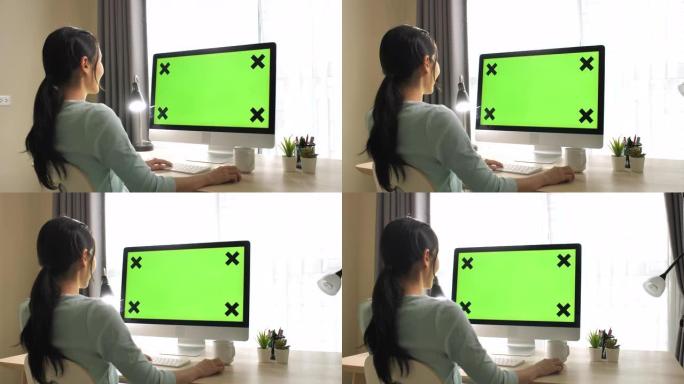 亚洲妇女在家中使用绿屏电脑