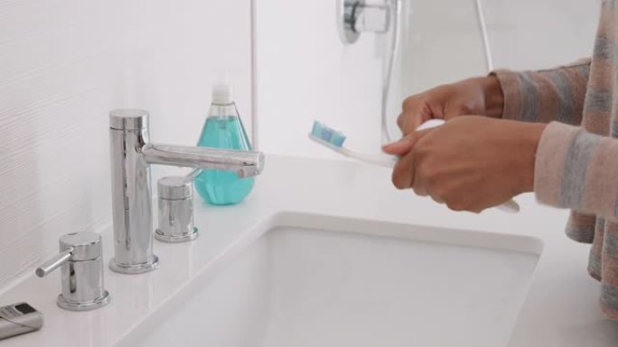 女人在浴室将牙膏挤在牙刷上的特写镜头