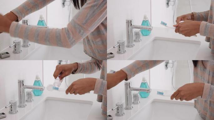 女人在浴室将牙膏挤在牙刷上的特写镜头
