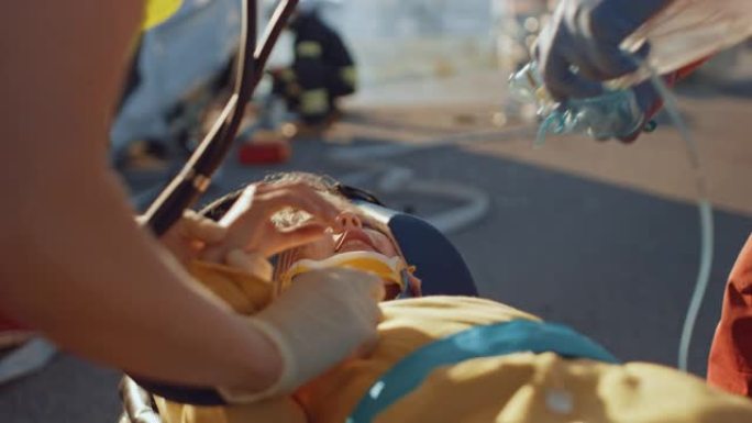 在车祸交通事故现场: 医护人员挽救了躺在担架上的交通事故受害者的生命。他们听心跳，戴上氧气面罩并提供