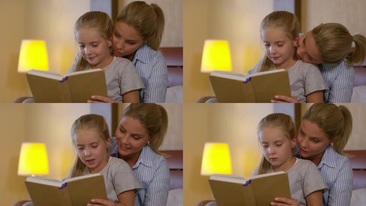 母亲拥抱女儿并阅读童话