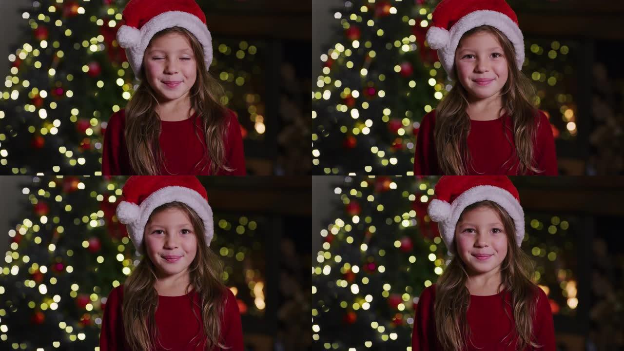 戴着圣诞老人帽子的可爱开朗小女孩的慢动作祝大家圣诞快乐。