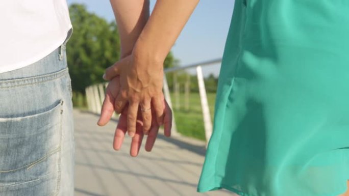 CLOSE UP: 女人穿她的承诺戒指保持她订婚的手在漫步