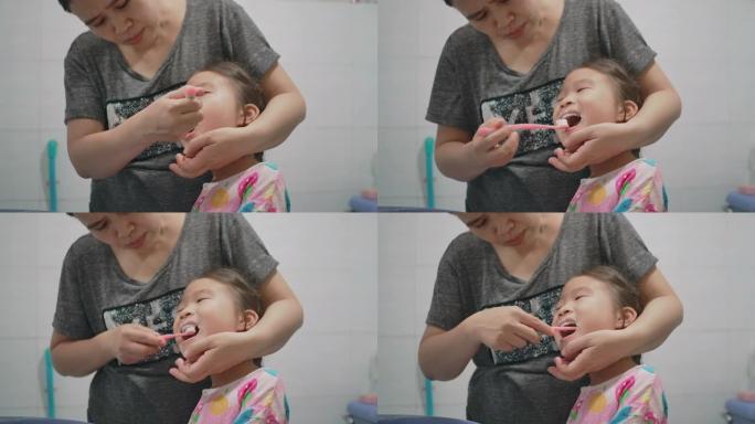 妈妈正在给女儿刷牙