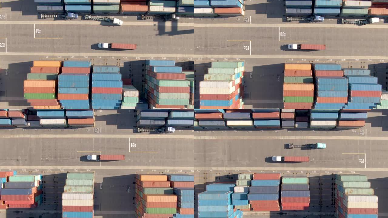 自上而下: 白色卡车在繁忙的港口运送一个红色的货运集装箱。